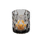 Clear glass candle holder with a candle inside on a white background