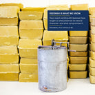 Stacks of filtered Texas beeswax beside a vintage honey extractor: beeswax is what we know