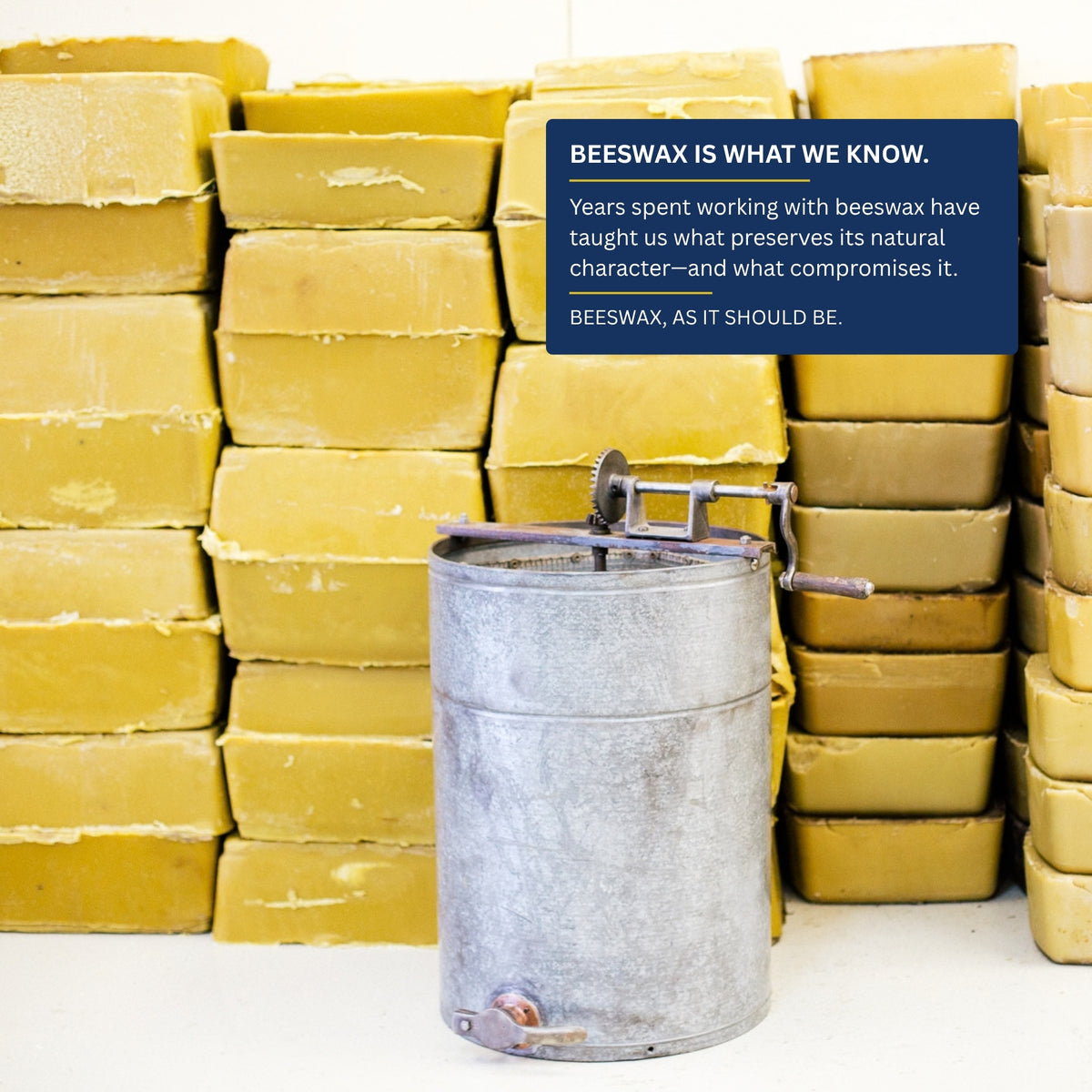 Stacks of filtered Texas beeswax beside a vintage honey extractor: beeswax is what we know